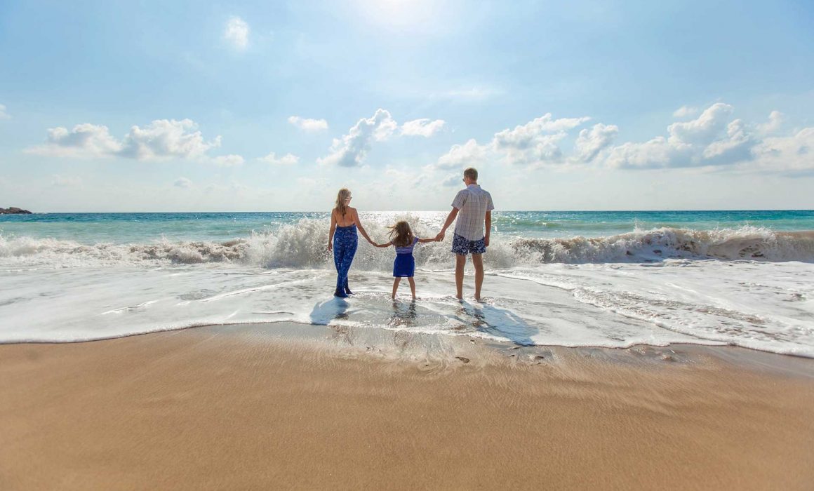 family on beach thinking about life risk sales
