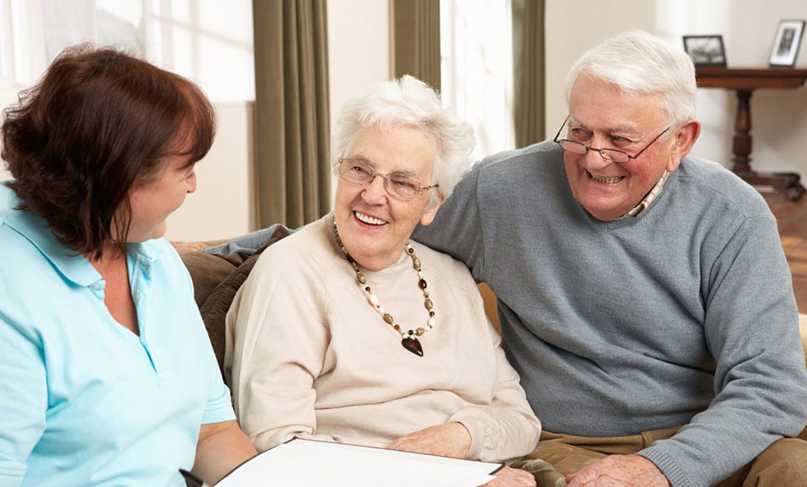elderly couple sitting on couch going through an aged care assessment